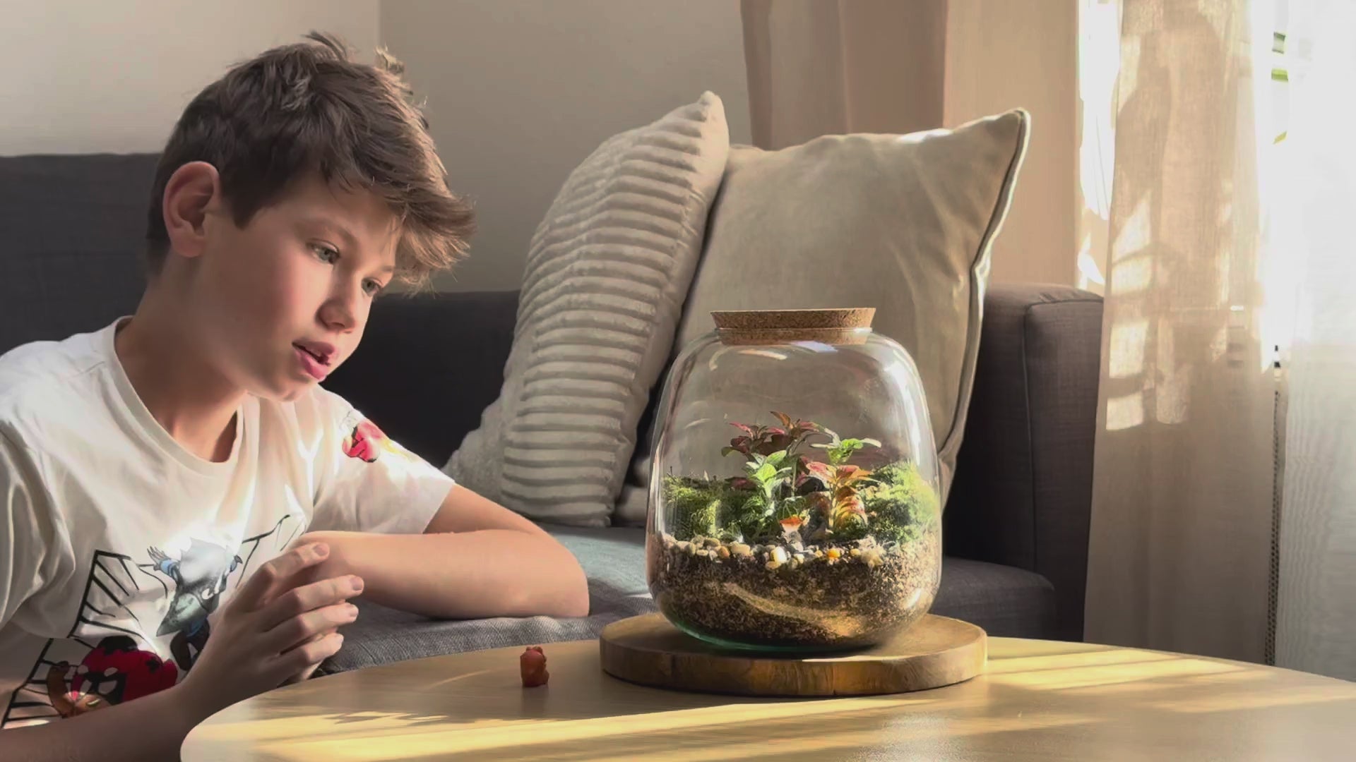 Enfant ajoutant une miniature dans un Kit/Pot M